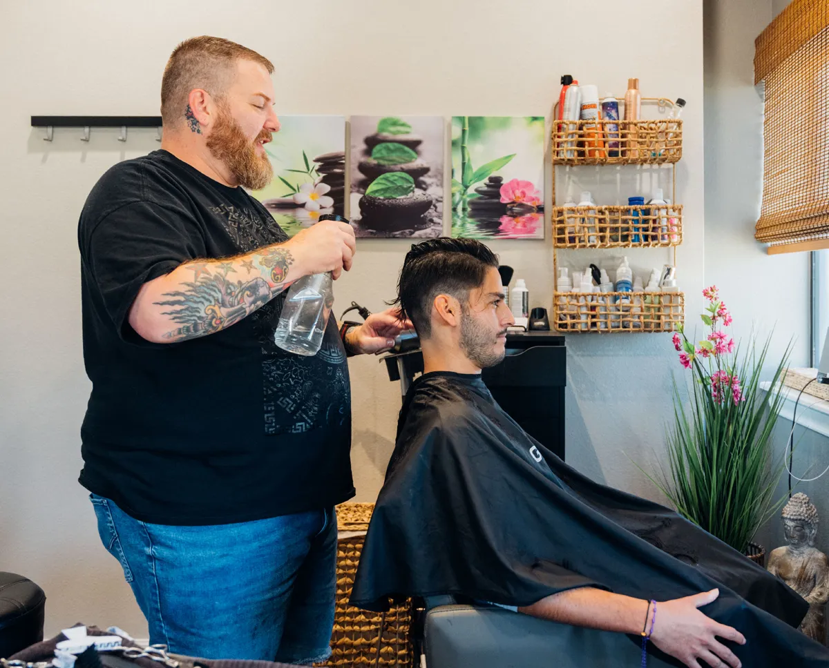 Male stylist cutting gentleman's hair
